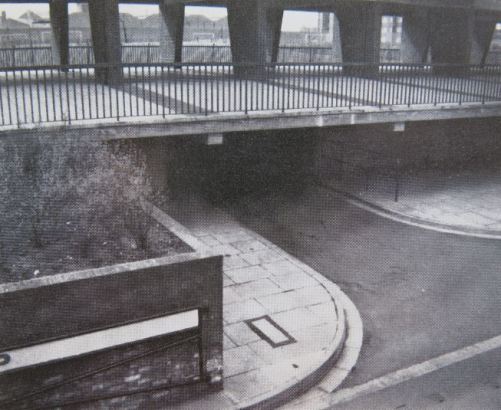 From the GLC brochure: 'Many of the garages are underground or incorporated in blocks but with separate access for vehicles.  Illustrated is an entrance to some garages with paved area above part of it under the block providing safe covered play areas for the use of children in wet weather'. 
